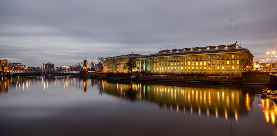En kreativ person som arbetar fokuserat vid ett skrivbord i en dynamisk miljö.